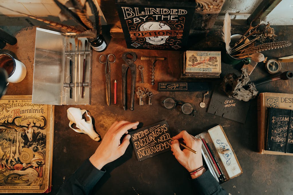 Artistic flat lay of a vintage workspace featuring rustic tools, stationery, and writing materials.
